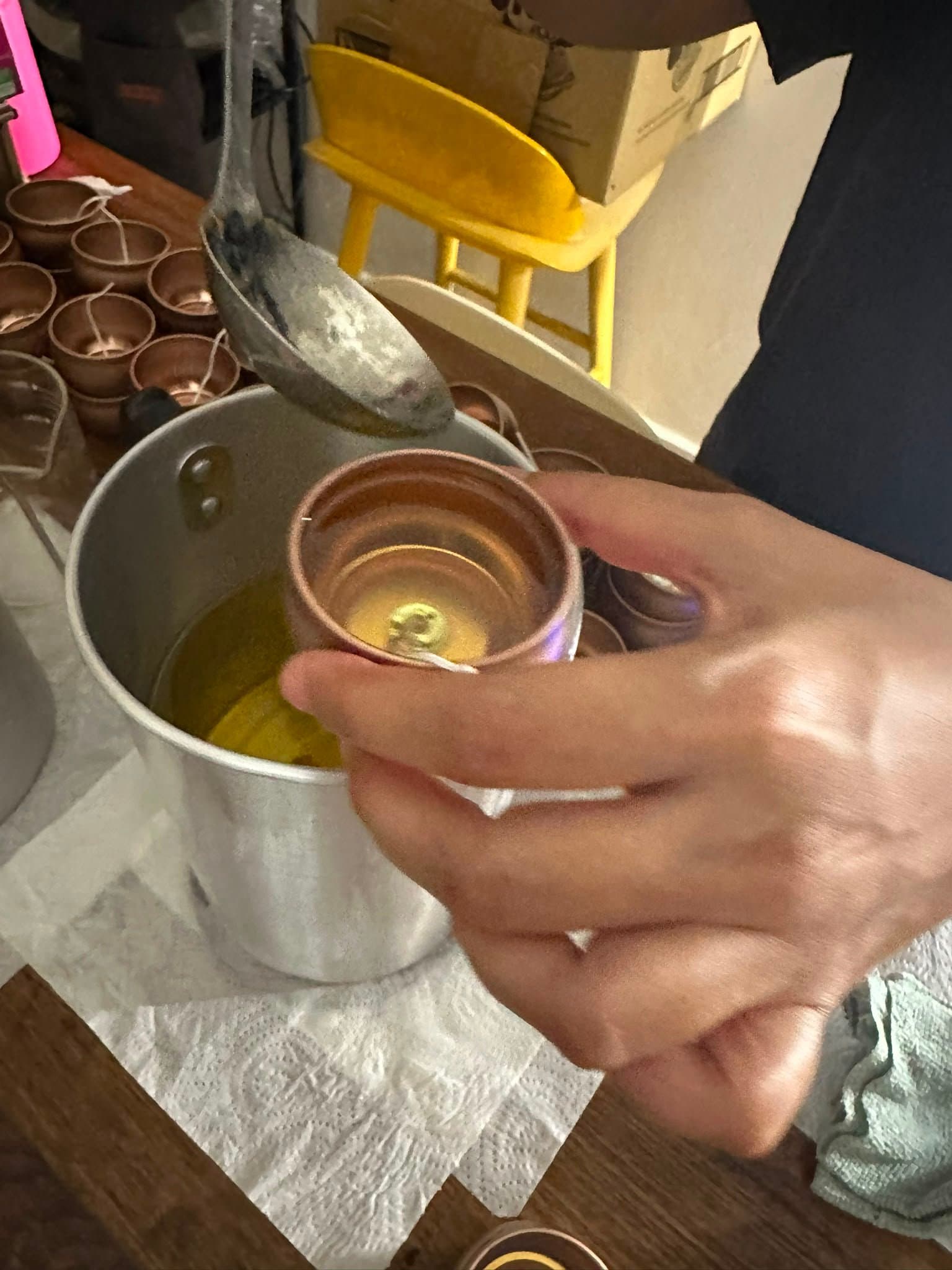 Hand pouring a candle at the 2ndStori studio